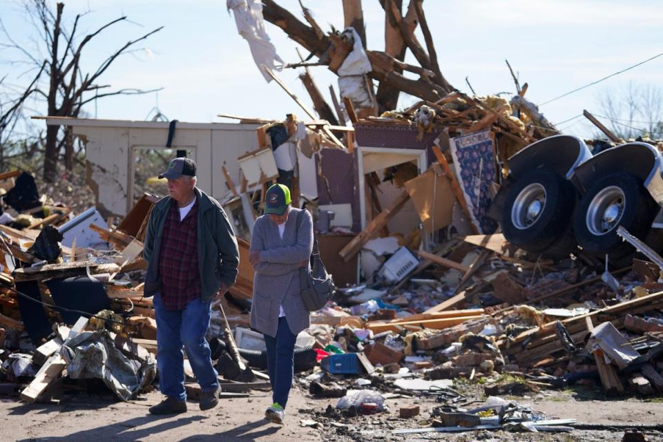 Two residents of Rolling Fork, Mississippi, visit the house of two friends who were killed when a semi truck landed on their home on Friday 24 March 2023 (AP Photo/Julio Cortez)