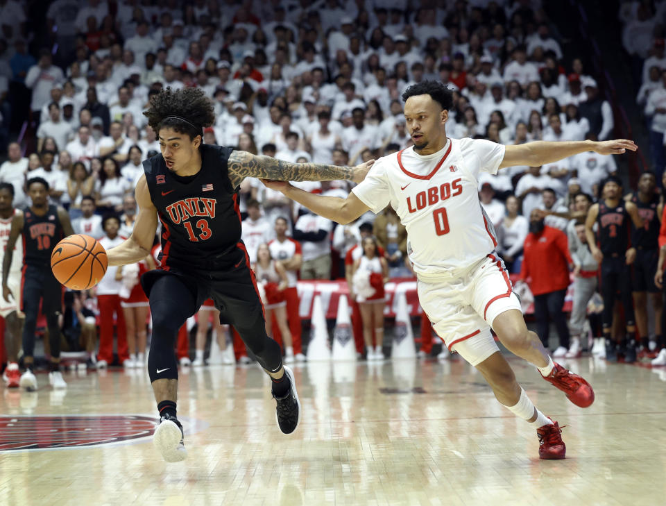 UNLV guard Brooklyn Hicks, left, and New Mexico guard Jamari Baker Jr. chase a loose ball during the first half of an NCAA college basketball game, Saturday, Feb. 10, 2024, in Albuquerque, N.M. (AP Photo/Eric Draper)