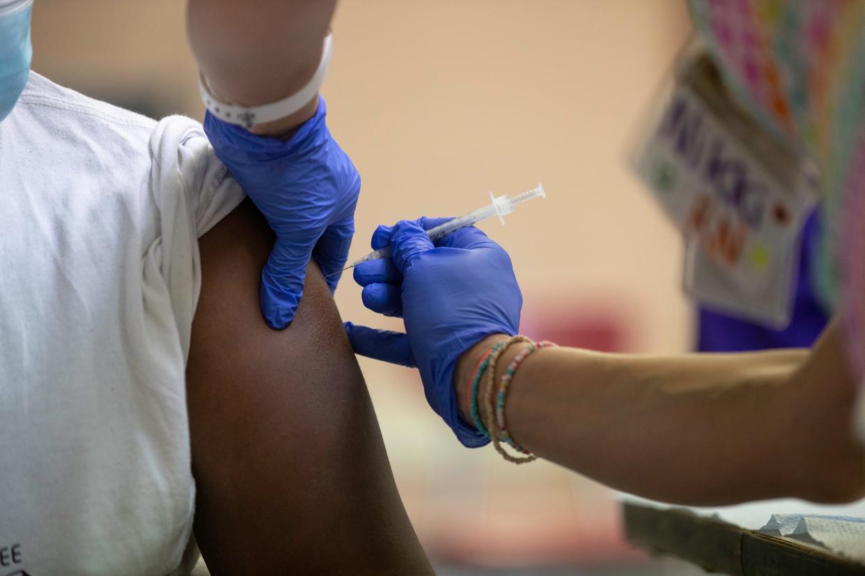 Registered nurse Nikki Mabes administers the COVID-19 vaccine to a student at Morse Middle School for the Gifted and Talented in 2021. Milwaukee Public Schools will receive more than $1 million of an $8.2 million investment to help K-12 schools across the state hire and retain school nurses.