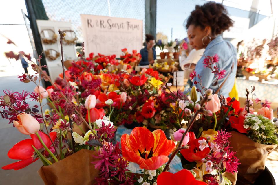 People shop for flowers from R&R Secret Farm at opening day of the spring Athens Farmers Market at Bishop Park in Athens, Ga., on Saturday, March 4, 2023. The spring market is held every weekend at Bishop Park and at Creature Comforts on Wednesdays.