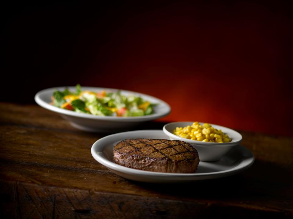 A top sirloin, side of corn and salad at Texas Roadhouse.