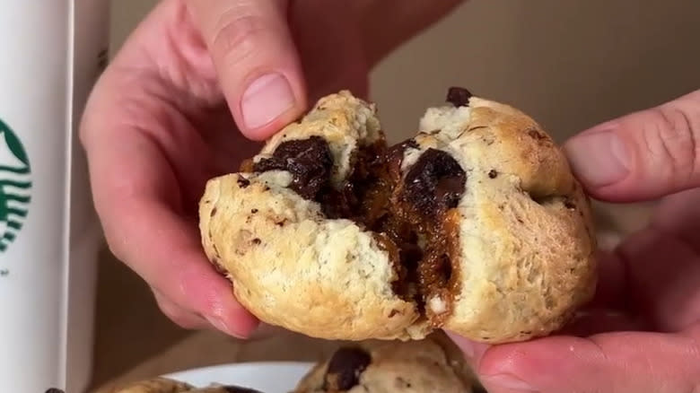 Hands splitting dulce de leche biscuit