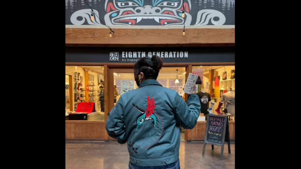 A model wears the Happy Hummingbird jacket and holds the Coast Salish pattern double-wall ceramic tumbler designed by Eighth Generation founder and Nooksack artist Louie Gong. The pieces are part of a five-item holiday collection launched in collaboration with Eighth Generation and Starbucks in November, 2021, which is Native American Heritage Month. The company, which was acquired by the Snoqualmie Indian Tribe in 2019, has become the first non-Starbucks store ever to carry products with the Starbucks Reserve logo.