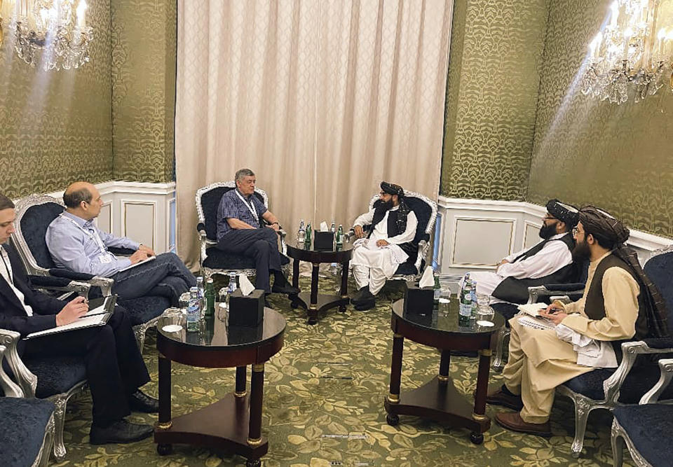 In this photo released by the Taliban Spokesman Office, Zabihullah Mujahid, the chief spokesman for the Taliban government who leads the Taliban delegation, center right, speaks with Russian Presidential Envoy to Afghanistan Zamir Kabulov, during a meeting in Doha, Qatar, Sunday, June 30, 2024. A Taliban delegation is attending a United Nations-led meeting in Qatar on Afghanistan after organizers said women would be excluded from the gathering. The two-day meeting is the third U.N.-sponsored gathering on the Afghan crisis. (Taliban Spokesman Office via AP)