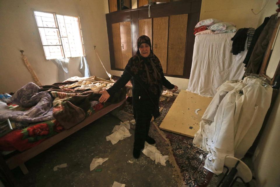 A Lebanese woman shows her damaged bedroom after a deadly car bombing Sunday night, in the town of Nabi Othman, about 30 kilometers (18 miles) north of Baalbek, northeast Lebanon, Monday, March 17, 2014. Lebanese security officials said the explosion killed at least two people and caused panic and massive destruction in the Hezbollah stronghold, which has a sizable Christian population in addition to Shiites. The civil war in neighboring Syria already has ignited polarizing sectarian tensions between Lebanon's Sunnis and Shiites. (AP Photo/Hussein Malla)