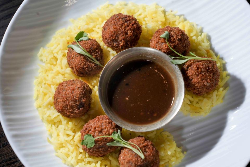 The Cheel's Lamb Bites are made with peanuts, onions, parsley, Parmesan and breadcrumbs. They're served over a bed of saffron rice and come with a dish of tangy tamarind aachar.
