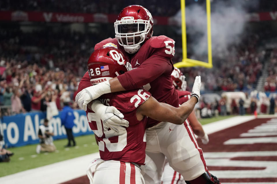 Oklahoma running back Kennedy Brooks (26) celebrates a touchdown against Oregon with Tyrese Robinson (52) during the first half of the Alamo Bowl NCAA college football game Wednesday, Dec. 29, 2021, in San Antonio. (AP Photo/Eric Gay)