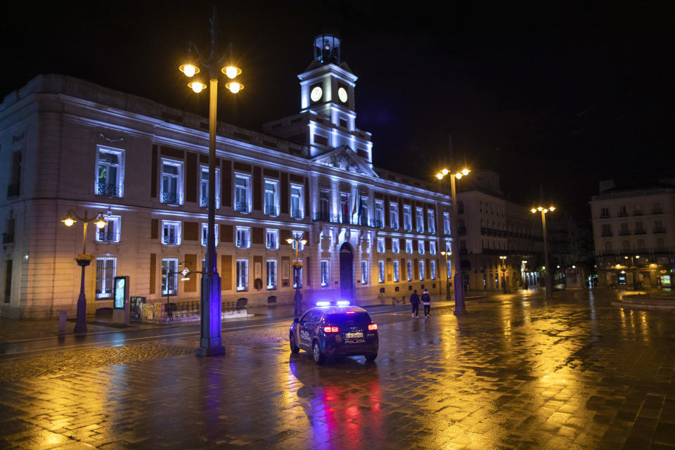 Un coche de policía patrulla la madrileña Puerta del Sol en el primer día del toque de queda nacional. (Photo by Pablo Blazquez Dominguez/Getty Images)