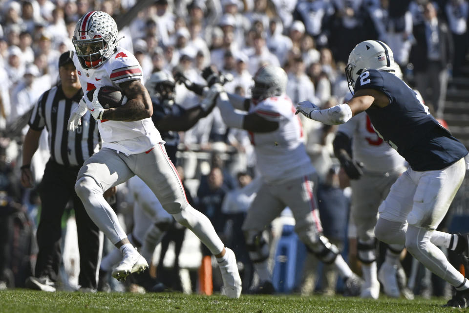 Ohio State wide receiver Julian Fleming (4) runs away from Penn State safety Keaton Ellis (2) during the first half of an NCAA college football game, Saturday, Oct. 29, 2022, in State College, Pa. (AP Photo/Barry Reeger)
