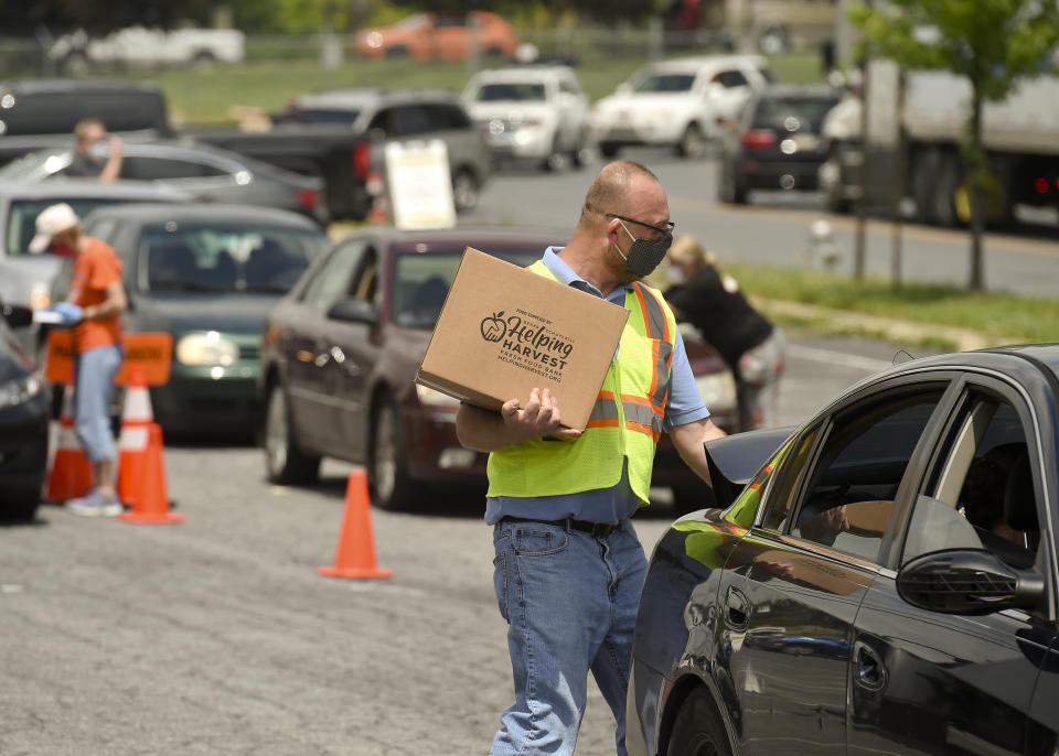 James Walton of Helping Harvest carries a box of food to a car during a pop-up food distribution in Reading, Pennsylvania, on May 29. (Photo: MediaNews Group/Reading Eagle via Getty Images)