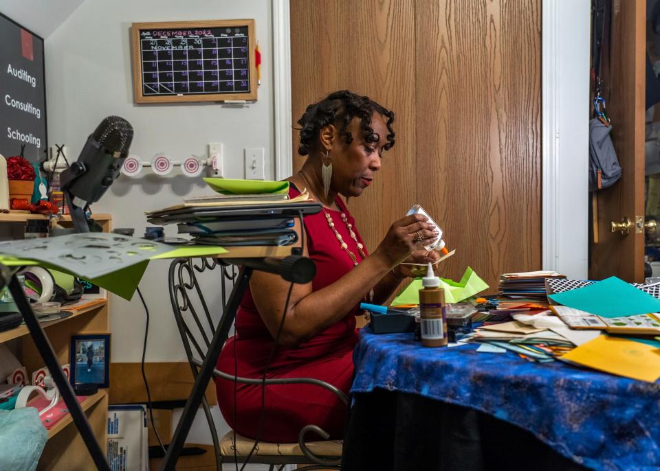 Alina Johnson, the owner of Johnson Consulting Services, works on creating handmade holiday greeting cards for friends and family at a workstation in the bedroom of her home in Detroit on Dec. 13, 2022. Johnson sometimes carves out substantial time to make the cards where she incorporates calligraphy and origami envelopes and also sells her creations to Detroiters and other local people who care enough to give cards that make a personal, heartfelt statement during the holiday season.