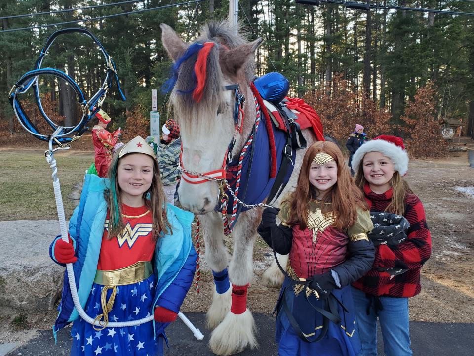 Super Horse and Invisible Horse, with their assistants, all 10 years old, Madison Colby, Adrianna Bolduc, and Jess Dowaliby at the Rochester Holiday Parade Sunday, Dec. 5, 2021.