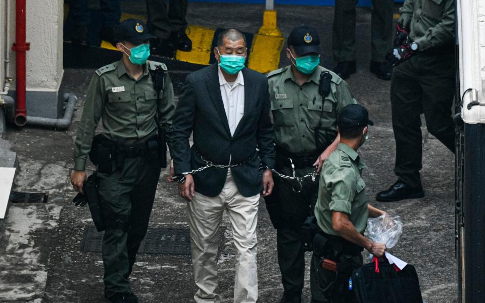 Mr Lai is seen handcuffed and escorted by guards leaving Lai Chi Kok Reception Centre - Getty Images