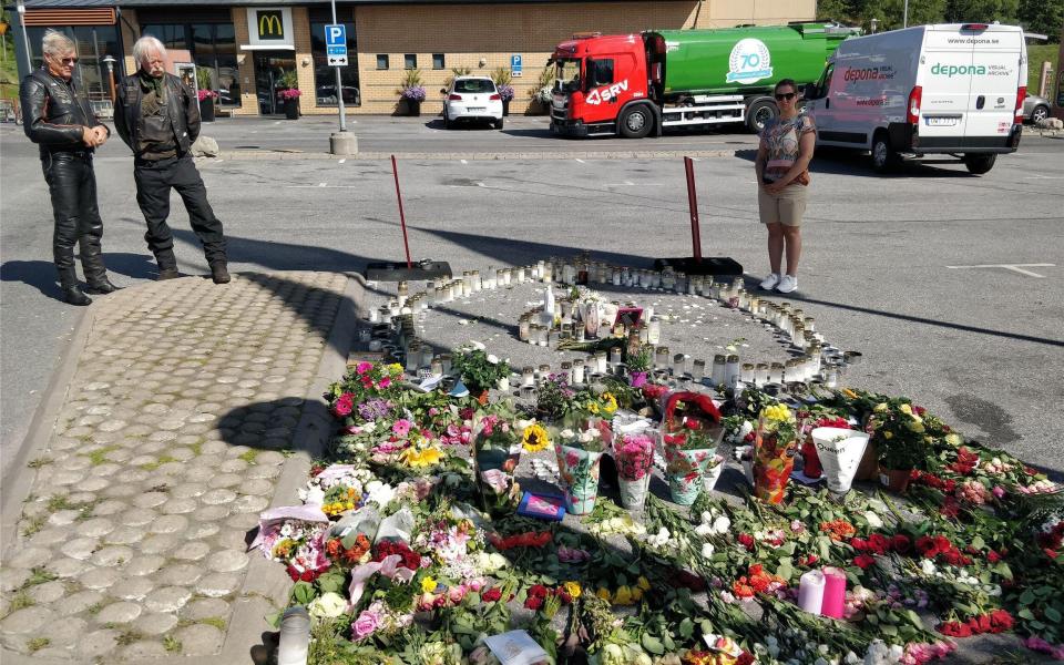 Flowers at the site where a 12-year-old girl was killed after being hit by a stray bullet in a gang shooting at a petrol station car park in Norsborg, south of Stockholm, Sweden - Xinhua / Alamy Live News