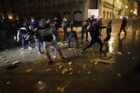 Anti-government protesters throw stones at the riot police during ongoing protests against the political elites who have ruled the country for decades, in Beirut, Lebanon, in Beirut, Lebanon, Wednesday, Jan. 22, 2020. (AP Photo/Hassan Ammar)