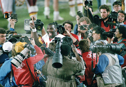 Washington quarterback Doug Williams is surrounded by members of the media after Super Bowl XXII.