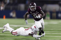 Arkansas defensive back Latavious Brini (7) trips Texas A&M running back Devon Achane (6) during the second half of an NCAA college football game Saturday, Sept. 24, 2022, in Arlington, Texas. Texas A&M won 23-21. (AP Photo/Brandon Wade)