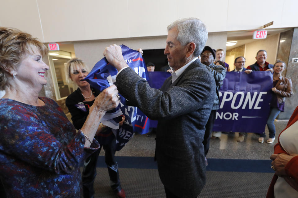 Louisiana Republican gubernatorial candidate Eddie Rispone signs a campaign banner as he greets supporters at a campaign stop in Shreveport, La., Friday, Nov. 15, 2019. (AP Photo/Gerald Herbert)
