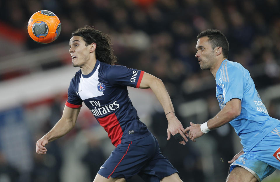 El delantero uruguayo Edinson Cavai del París Saint Germain disputa un balón con Jeremy Morel del Marsella en el partido de la liga francesa el domingo 2 de marzo de 2014. (AP Foto/Lionel Cironneau)