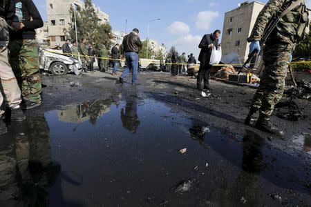 Syrian army soldiers and civilians inspect the site of a suicide bombing at a police officers' club in a residential district of Damascus, in Masaken Barza, Syria February 9, 2016. REUTERS/Omar Sanadiki