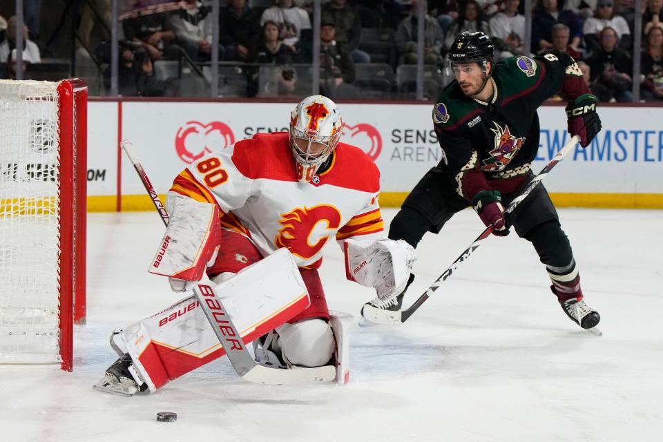 Calgary Flames goaltender Dan Vladar (80) makes the save in front of Arizona Coyotes center Nick Schmaltz in the first period during an NHL hockey game, Wednesday, Feb. 22, 2023, in Tempe, Ariz. (AP Photo/Rick Scuteri)