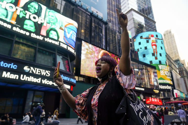 Aniya A hace gestos mientras camina por Times Square en Nueva York; habla por su teléfono celular después de que un jurado de Minnesota encontrara al exoficial de policía de Minneapolis Derek Chauvin culpable de asesinato y homicidio involuntario en la muerte de George Floyd, martes 20 de abril de 2021