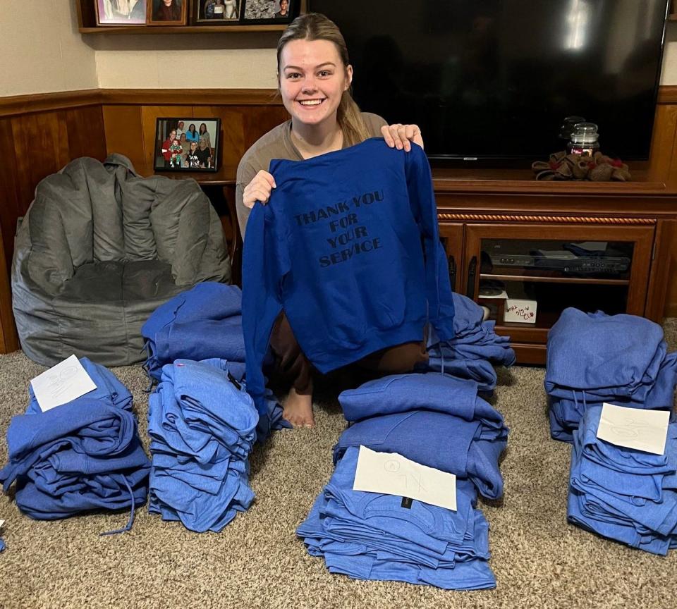 Aliah Williamson with T-shirts she made and sold last year as part of her Heroes of Today initiative. Funds were used to award two scholarships. Williamson will make and sell new T-shirts this spring to fund more scholarships related to her senior project.