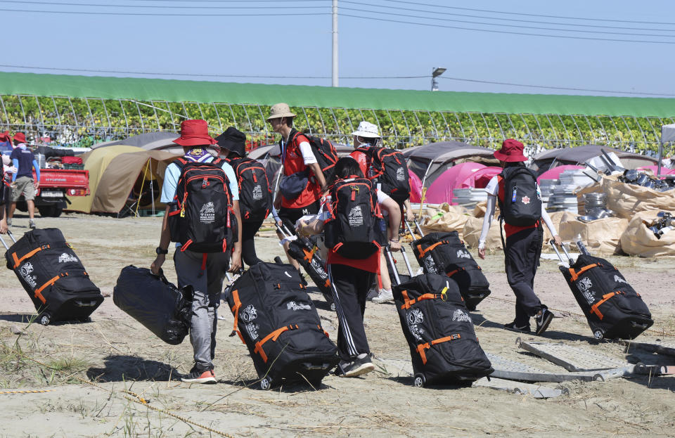 Attendees of the World Scout Jamboree leave a scout camping site in Buan, South Korea, Tuesday, Aug. 8, 2023. Buses began moving thousands of global Scouts from their campsite on South Korea's coast to inland venues Tuesday ahead of a tropical storm that is forecast to bring intense rains and strong winds to the peninsula within days. (Na Bo-bae/Yonhap via AP)