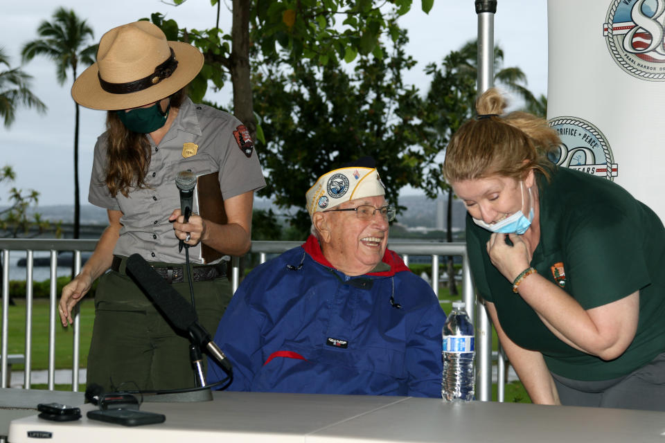 Pearl Harbor survivor Herb Elfring, center, speaks with National Park Service workers in Pearl Harbor, Hawaii on Sunday, Dec. 5, 2021. A few dozen survivors of Pearl Harbor are expected to gather Tuesday, Dec. 7 at the site of the Japanese bombing 80 years ago to remember those killed in the attack that launched the U.S. into World War II. (AP Photo/Audrey McAvoy)