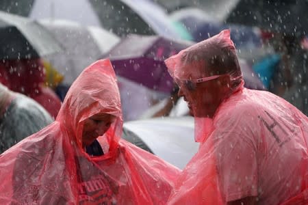 People stand in the rain at a rally for U.S. President Donald Trump at the Amway Center in Orlando