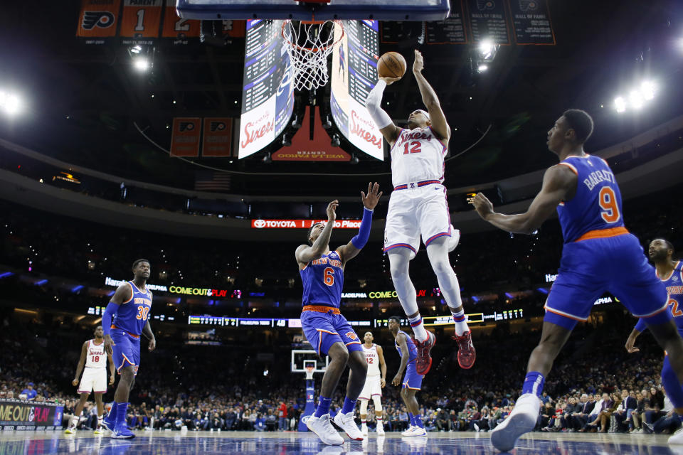 Philadelphia 76ers' Tobias Harris (12) goes up for a shot against New York Knicks' Elfrid Payton (6) and RJ Barrett (9) during the first half of an NBA basketball game, Thursday, Feb. 27, 2020, in Philadelphia. (AP Photo/Matt Slocum)