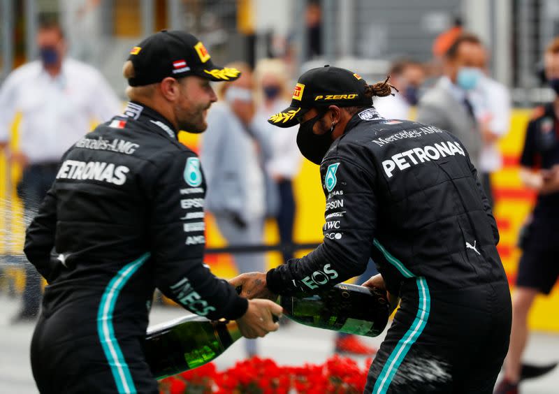 Lewis Hamilton de Mercedes (derecha) lleva una mascarilla mientras celebra después de ganar la carrera, con el segundo puesto de Mercedes, Valtteri Bottas, tras la reanudación de la F1 después del brote de la enfermedad coronavirus (COVID-19)