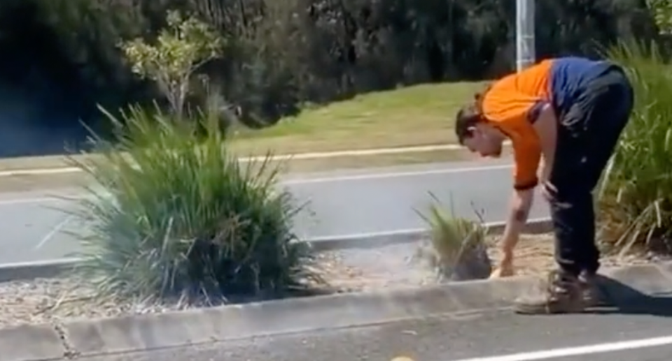 Image of local tradie using XXXX Beer can to put out fire. 