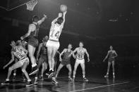 FILE - In this March 26, 1953, file photo, Bob Cousy (14) of the Boston Celtics takes a rebound off the backboard after an attempted basket by Dick McGuire (15) of the New York Knickerbockers in the fourth quarter of their NBA playoff game at the Boston Garden in Boston, Mass. (AP Photo/Bill Chaplis, File)