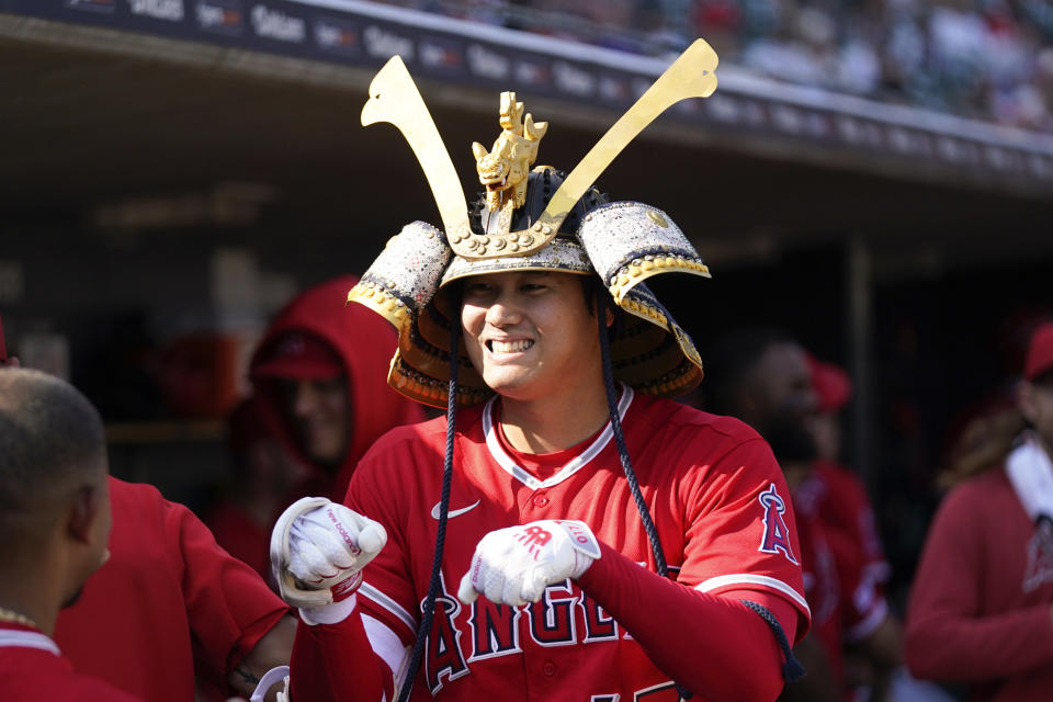 El japonés Shohei Ohtani festeja con un casco de samurai tras conectar un jonrón ante los Tigres de Detroit, el jueves 27 de julio de 2023 (AP Foto/Paul Sancya)