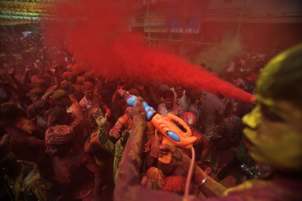 Indians throw colored powder and dance during celebrations marking Holi, the Hindu festival of colors, in Gauhati, India, Monday, March 17, 2014. The holiday, celebrated mainly in India and Nepal, marks the beginning of spring and the triumph of good over evil. (AP Photo/Anupam Nath)