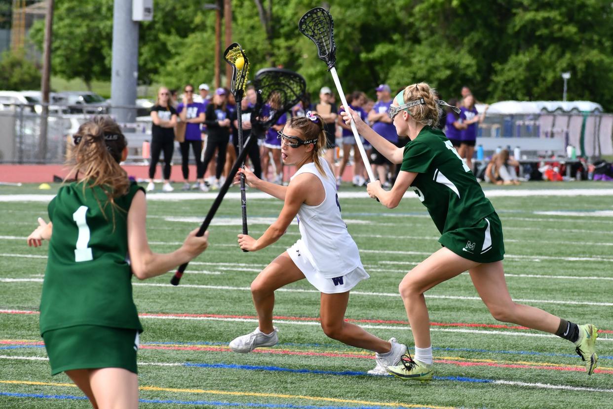 Cherry Hill West freshman Tatum Woods drives ont he goal between Mainland sophomore Jillian Schallus and junior Jane Meade