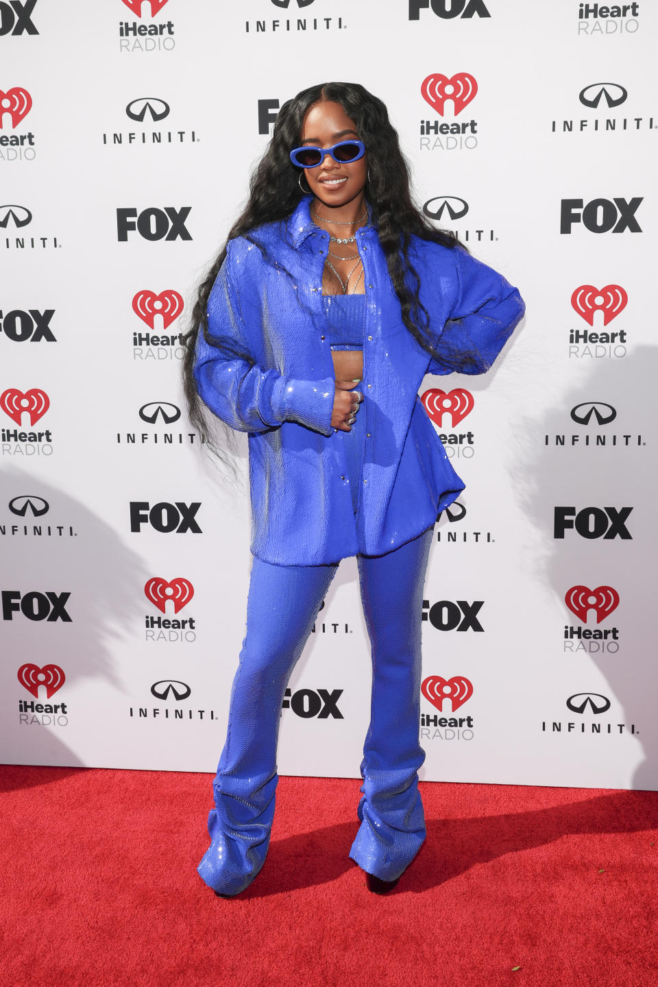 <p>H.E.R. said “yes” to monochrome in this electric blue outfit made up of bell-bottomed pants, a cropped top, an overshirt, and matching sunglasses. </p>