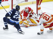 Calgary Flames goaltender Dustin Wolf (32) makes a save against Winnipeg Jets' Mason Appleton (22) during the third period of an NHL hockey game Thursday, April 4, 2024, in Winnipeg, Manitoba. (John Woods/The Canadian Press via AP)