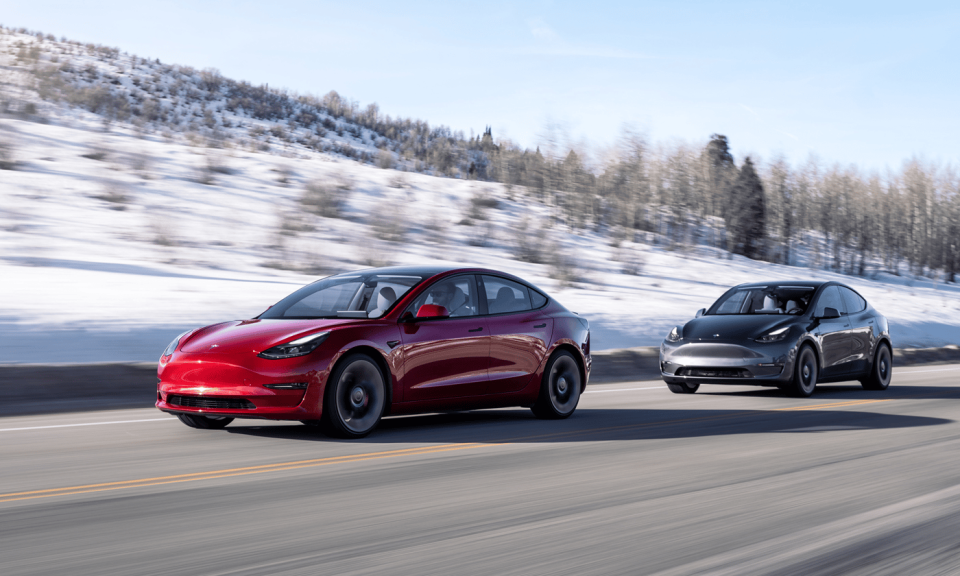 Two Tesla sedans in a line driving on a road.