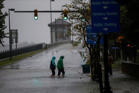 People walk on a local street as water from Neuse River starts flooding houses upon Hurricane Florence coming ashore in New Bern, North Carolina, U.S., September 13, 2018. REUTERS/Eduardo Munoz