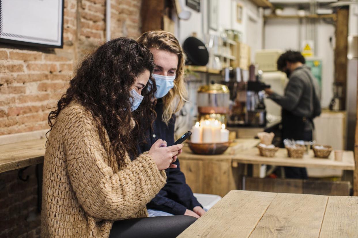 <span class="caption">Masking indoors will yet again be the new normal in Los Angeles County -- and possibly elsewhere in the U.S.</span> <span class="attribution"><a class="link " href="https://www.gettyimages.com/detail/photo/happy-couple-in-love-with-face-mask-in-coffe-shop-royalty-free-image/1299333015" rel="nofollow noopener" target="_blank" data-ylk="slk:Lourdes Balduque/ Moment via Getty Images;elm:context_link;itc:0;sec:content-canvas">Lourdes Balduque/ Moment via Getty Images</a></span>