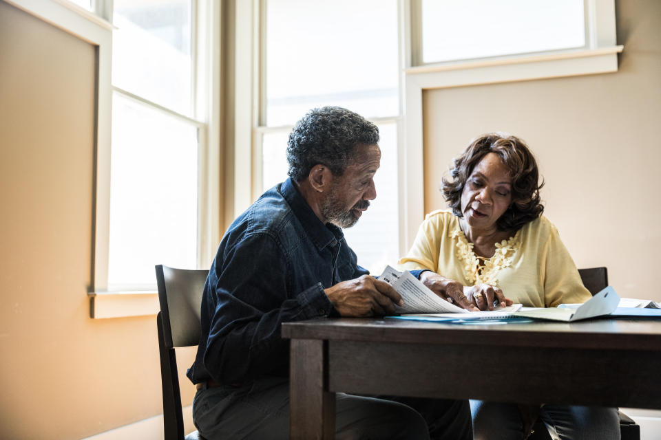 Senior couple paying bills at home