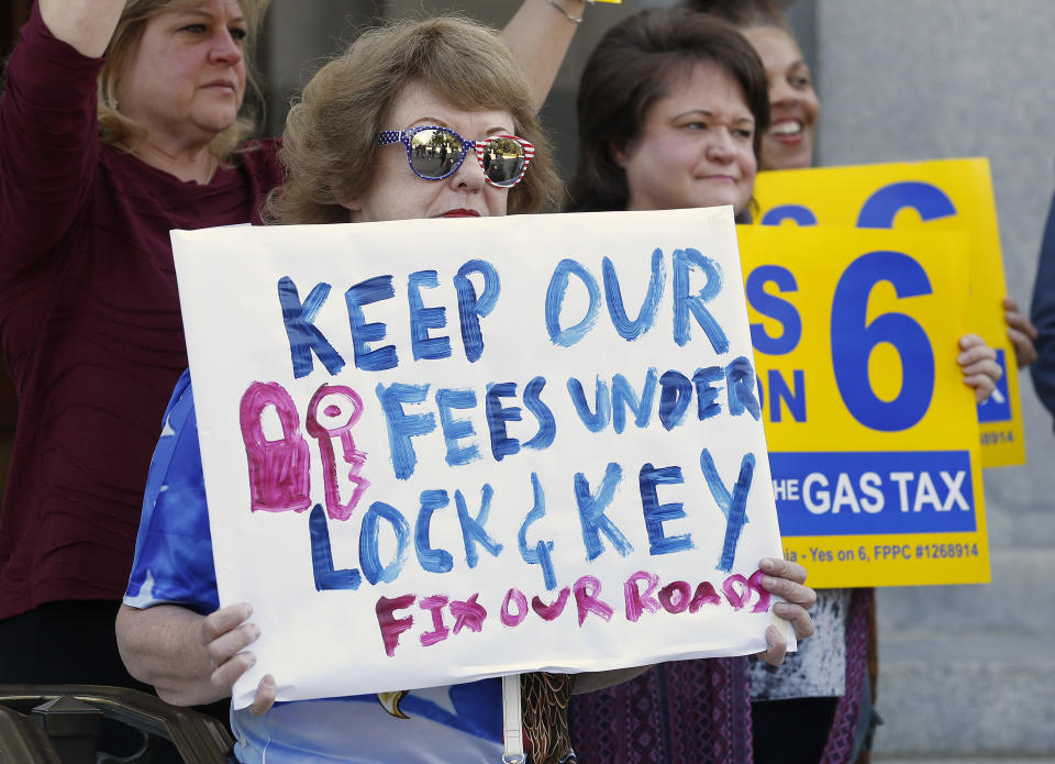 Carol Stearns, left, joins other at a news conference to support a proposed ballot measure to provide money for road repairs and eliminate high-speed rail on Tuesday, Sept. 25, 2018, in Sacramento, Calif. The 2020 initiative would change the state constitution to require that revenue from existing gas taxes be spent only for road and bridge work. (AP Photo/Rich Pedroncelli)