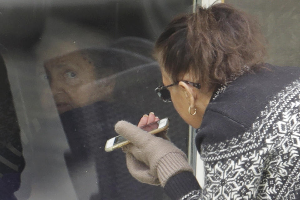 Carmen Gray, right, talks with her mother, Susan Hailey, left, who has tested positive for the new coronavirus, through the window of Hailey's room at the Life Care Center in Kirkland, Wash., Tuesday, March 17, 2020, near Seattle. In-person visits are not allowed at the nursing home, which has been at the center of the outbreak of new coronavirus in the state. (AP Photo/Ted S. Warren)