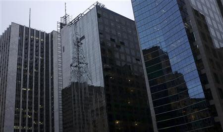 Workers suspended on ropes work on a new business building at the financial centre of Sao Paulo's Avenida Paulista April 21, 2014. REUTERS/Nacho Doce