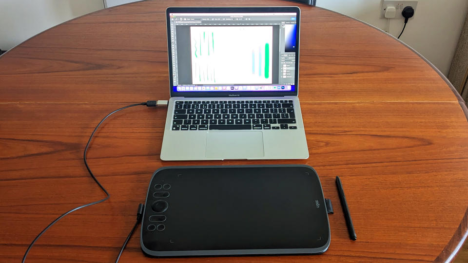 Ugee M908 review; a drawing tablet connected to a laptop