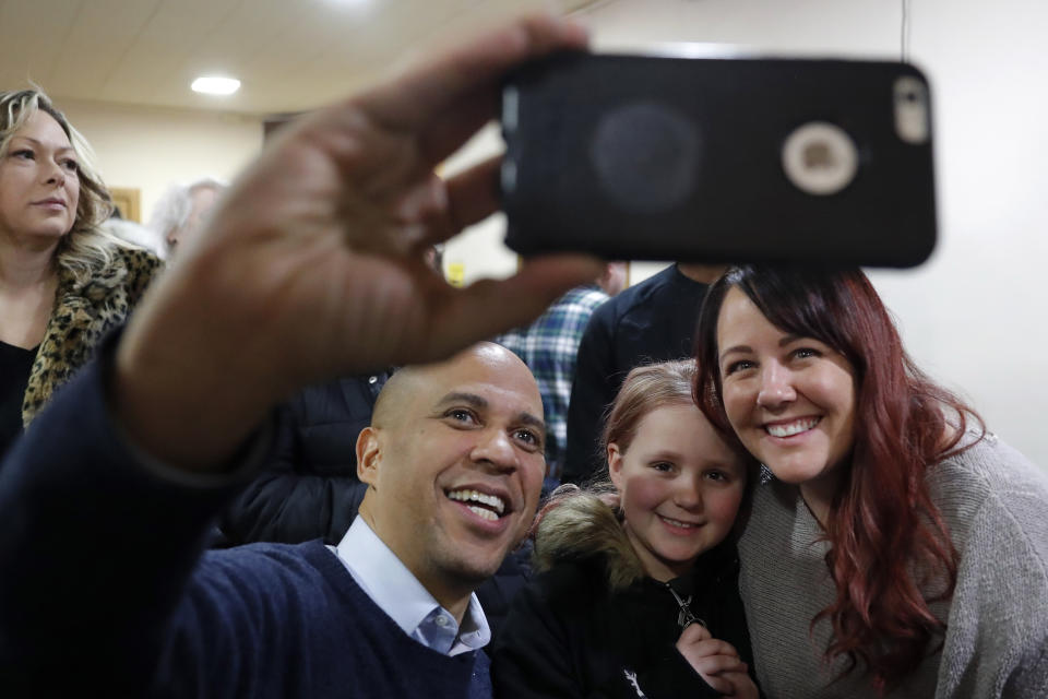 U.S. Sen. Cory Booker, D-N.J., poses for a photo with Alyssa Benson, of Mason City, Iowa, right, and her daughter Jersey, center, during a meet and greet with local residents at the First Congregational United Church of Christ, Friday, Feb. 8, 2019, in Mason City, Iowa. (AP Photo/Charlie Neibergall)