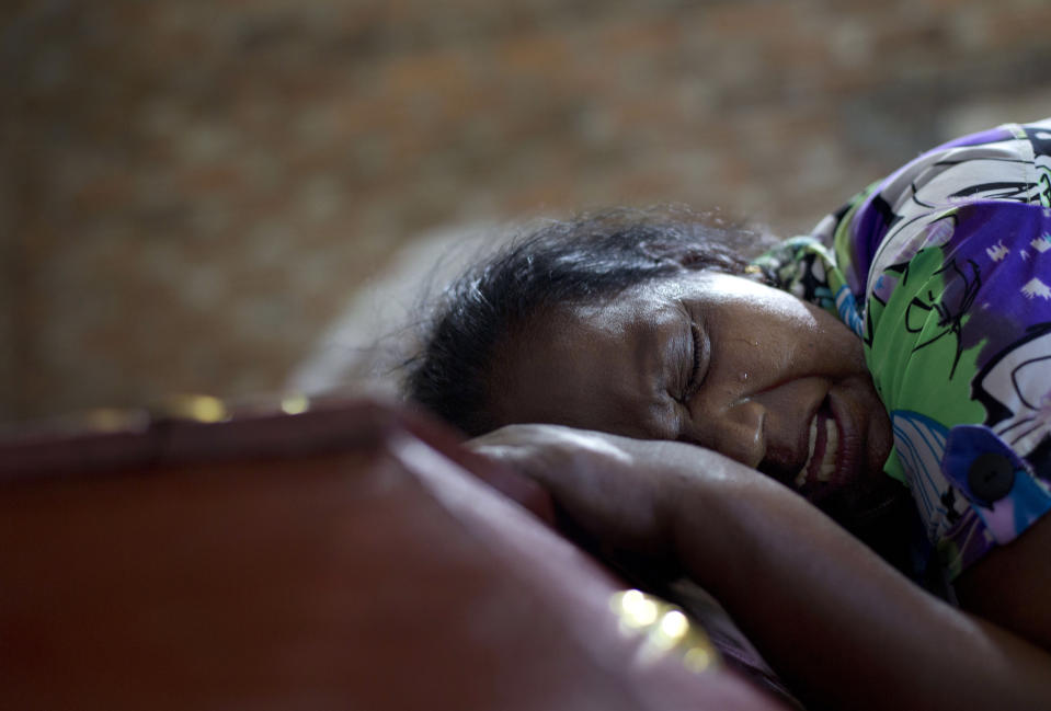 FILE - In this April 22, 2019 file, photo, Lalitha weeps on the coffin with the remains of 12-year old niece, Sneha Savindi, who was a victim of Easter Sunday bombing at St. Sebastian Church in Negombo, Sri Lanka. In a video released on April 29, the Islamic State group's leader extolled militants in Sri Lanka for “striking the homes of the crusaders in their Easter, in vengeance for their brothers in Baghouz,” a reference to IS’ last bastion in eastern Syria, which was captured by U.S.-backed fighters in March. (AP Photo/Gemunu Amarasinghe, File)