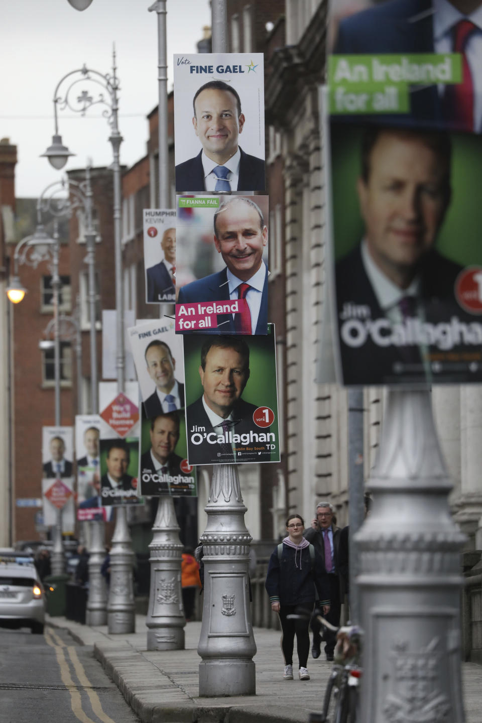 Election posters are displayed on lampposts outside the Irish Prime Minister offices in Dublin, Ireland, Friday, Feb. 7, 2020. Irish voters will choose a new parliament on Saturday, and may have bad news for the two parties that have dominated the country’s politics for a century, Fianna Fail and Fine Gael. Polls show a surprise surge for Sinn Fein, the party historically linked to the Irish Republican Army and its violent struggle for a united Ireland. (AP Photo/Peter Morrison)